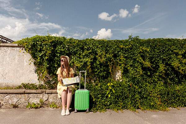 femme assise avec une valise et une carte