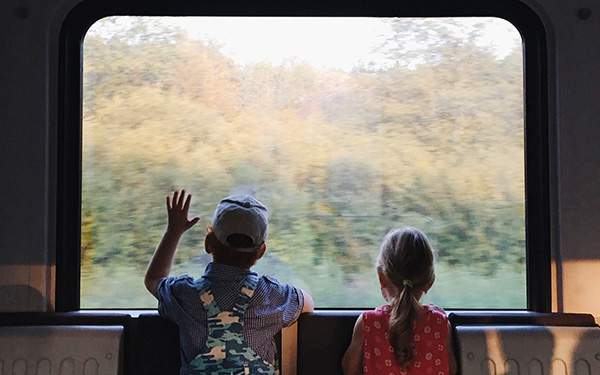 voyage écoresponsable en famille en europe avec enfants regardant à travers la vitre d'un train