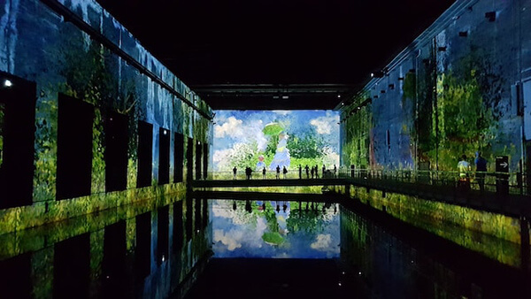 intérieur des bassins des lumières de Bordeaux, avec une peinture qui se réflète dans l'eau des bassins